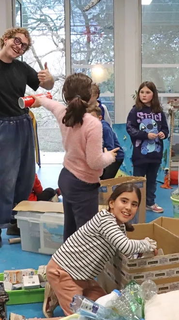 des enfants et un animateur scotchent des cartons