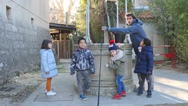 des enfants et un animateur sont devant le puits