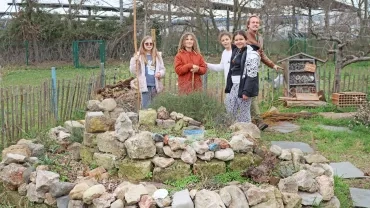 un groupe d'enfants et leur animateur sont dans un jardin