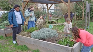 Deux animateurs et des enfants sont dans un jardin