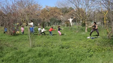 un adulte tire sur une corde tendue par tout un groupe d'enfants