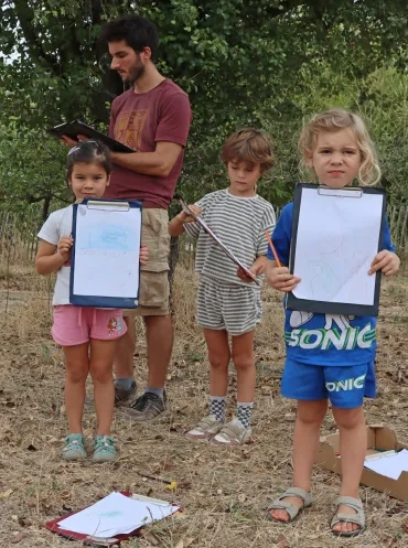 Un groupe d'enfants et leur animateur montrent des dessins