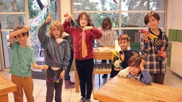 un groupe d'enfants montre les rouleux de papier toilette peints et ornés de bandelettes colorées