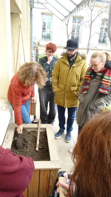 L'animatrice retourne la terre du bac.