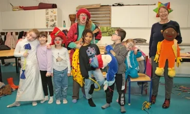un groupe d'enfants et leurs animatrices posent avec des déguisements et des marionnettes