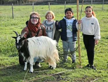 un groupe d'enfants et leur animateur posent avec un bouc