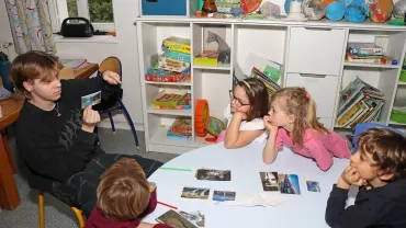 un groupe d'enfants et leur animateur observent des images illustrant les énérgies