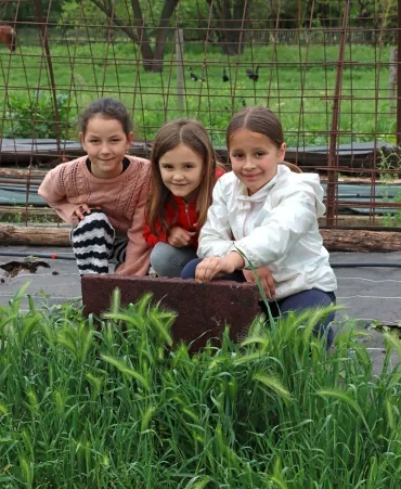 tris enfants soulèvent des dalles