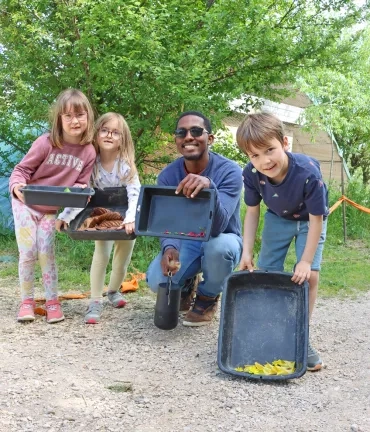 Un groupe d'enfants et leur animateur montrent des éléments naturels