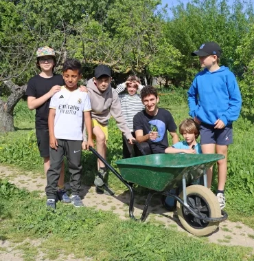 Un groupe d'enfants et leur animateur montrent des touffes d'herbe