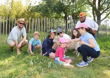 Un groupe d'enfants et leurs animateurs sont avec un agneau