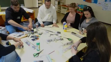 Les participants réalisent des pots en papier journal.