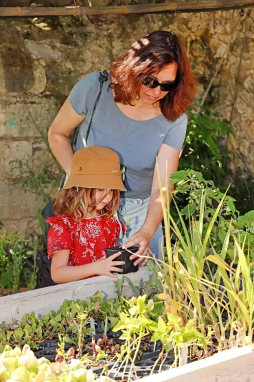 une maman et sa fille tiennent un pot de bouture