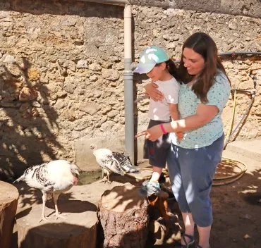 une mère et sa fille s'approchent d'une dinde