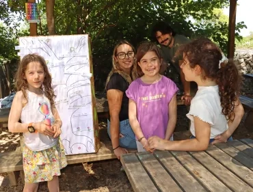 Un groupe d'enfants et leurs animateur sont à côté d'un dessin d'arbre