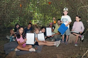 Un groupe d'enfants et leur animateur montrent des dessins