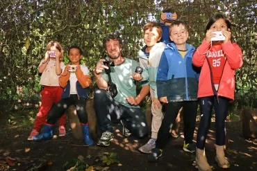 Un groupe d'enfants et leur animateur prennent des photos