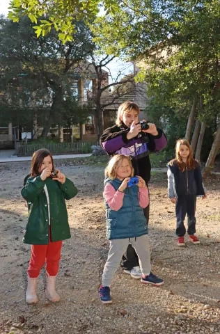 trois enfant et leur animateur prennent des photos