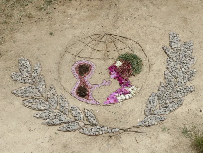 Logo de l'Unicef en land'art réalisé avec des éléments naturels : pierres, branches, fleurs, feuilles, graines......