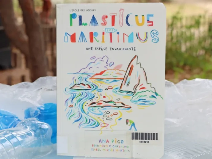 Le livre Plasticus maritimus est exposé entouré de déchets en plastique