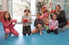 Un groupe d'enfants et leur animatrice montrent leurs appareils photos en carton