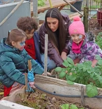 un goupe d'enfants et leur animatrice regarde des plantations dans la serre