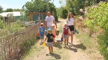 un groupe d'enfants et leur animateur marchent avec des arrosoirs