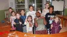 un groupe d'enfants et leur animateur montrent des cerceaux de bois avec de la laine à l'intérieur