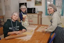 Un groupe d'enfants en cuisine montrent leurs morceaux de pâte