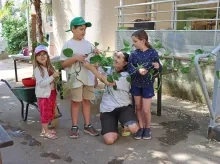 une groupe d'enfants et leur animatrice tiennent une liane