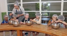 une groupe d'enfants et leur animatrice cassent des oeufs en cuisine