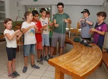 Un groupe d'enfants et leur animateur manipulent des morceaux de ficelle