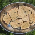 Des crackers dans un plat sont disposés sur du romarin