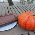 2 gâteaux marron dans une assiette à coté d'une courge sur une table en bois