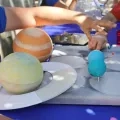 Mains d'enfants autour de maquettes de planètes