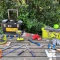 Photo d'outils et d'une malle de bricolage disposés sur une table avec une autre malle en arrière plan