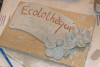 Une plaque d'argile décorée de fleurs avec l'inscription « Ecolothèque »