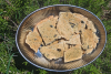 Des crackers dans un plat sont disposés sur du romarin