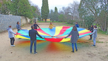 Les participants tiennet une toile de parachute multicolore