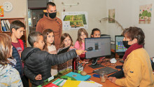 Un groupe d'enfants et leur animateur interrogent la directrice de l'Écolothèque dans son bureau