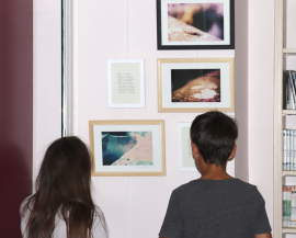 Deux enfants de dos regardent les photographies de l'artiste