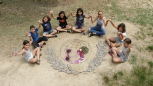 Des enfants se tiennent la main autour du logo de l'Unicef créé en éléments naturels