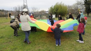 Des parents et des enfants coopèrent en jouant au parachute, une toile tendue colorée tenue par tous
