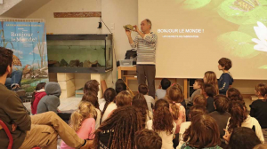 Le réalisateur montre la tortue en papier devant un groupe d'enfants
